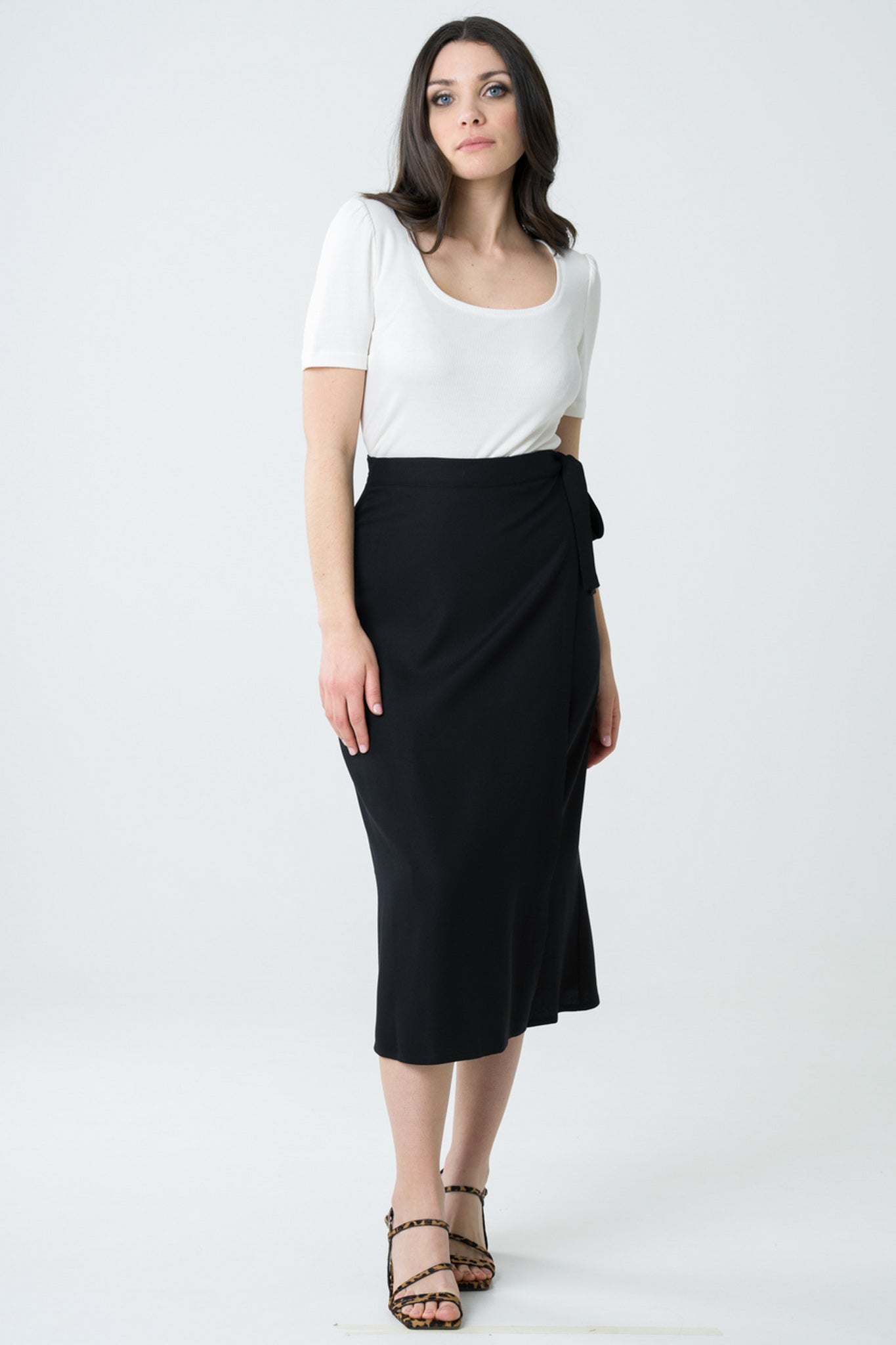 Jupe portefeuille noire mi-longue en viscose Ecovero, fabriquée au Portugal de manière éthique, avec une coupe flatteuse et un tissu fluide pour un look élégant et durable.
