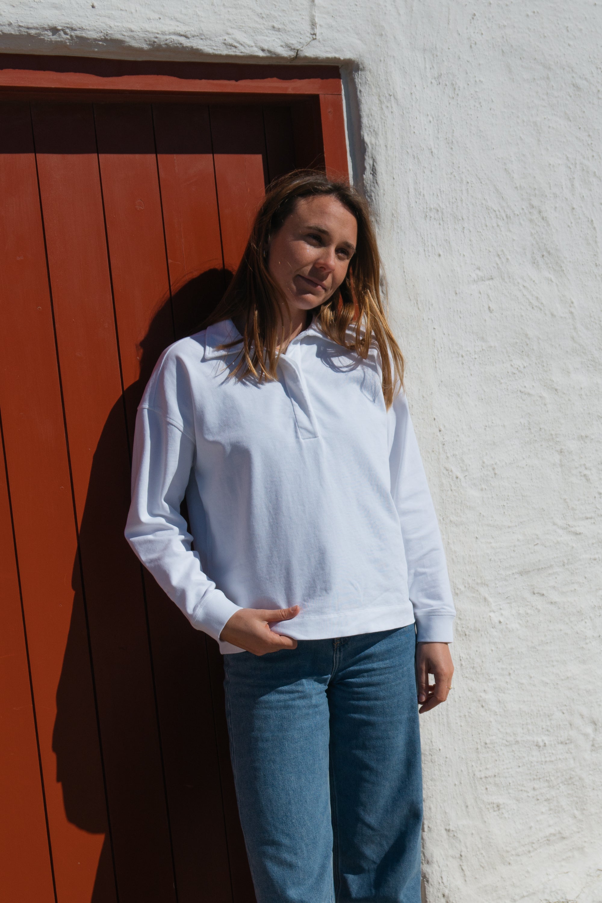 Frau trägt GOTS-zertifiziertes weißes Polo Longsleeve von SALZWASSER  _women