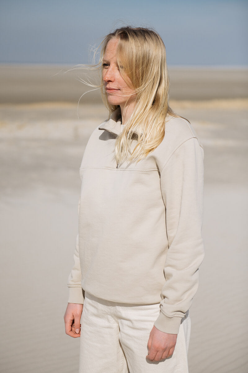 Frau trägt sand-farbigen Sweater mit Reißverschluss am Strand von SALZWASSER _women