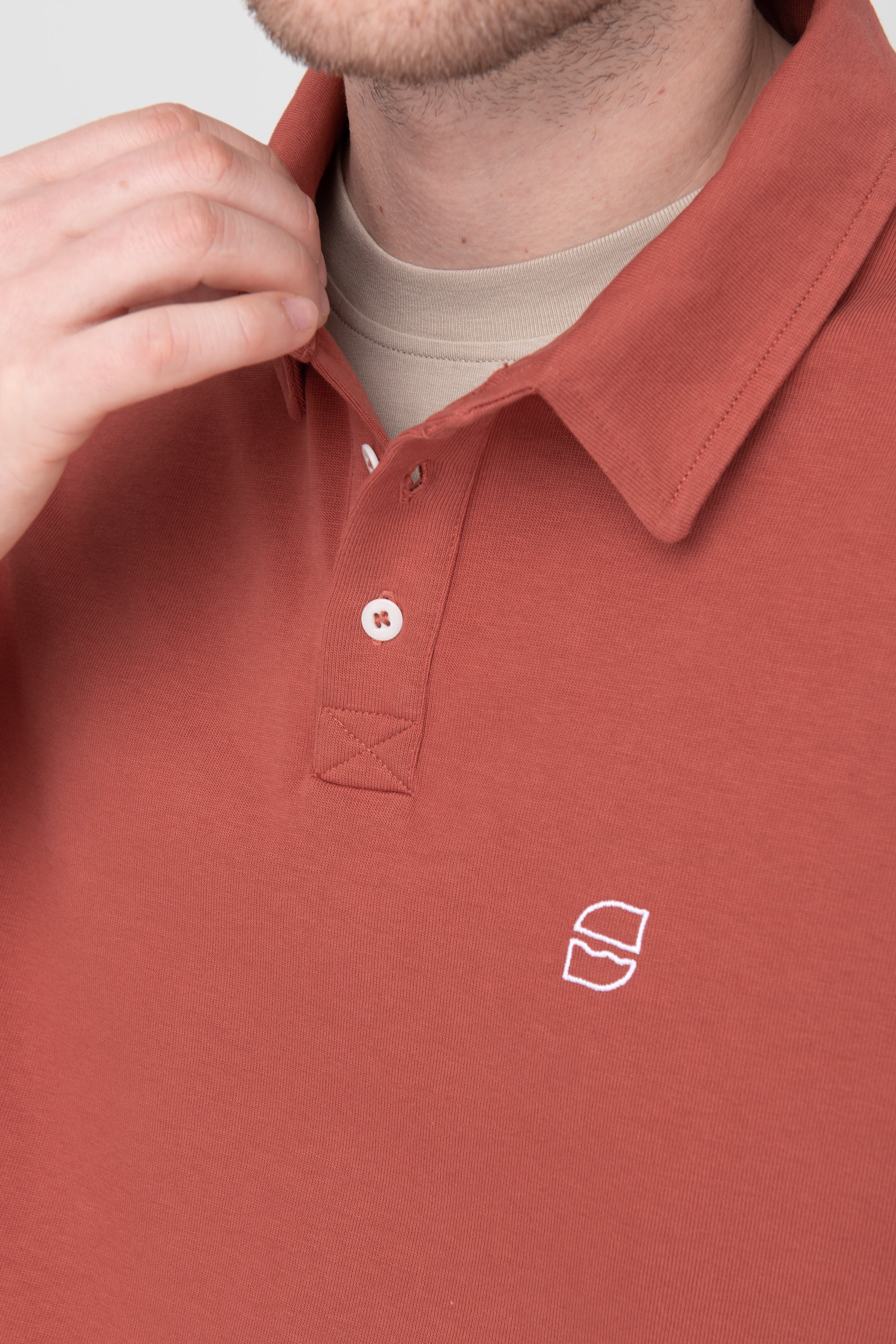 schlichtes Polo Longsleeve in Rostrot mit weißer SALZWASSER-Stickerei