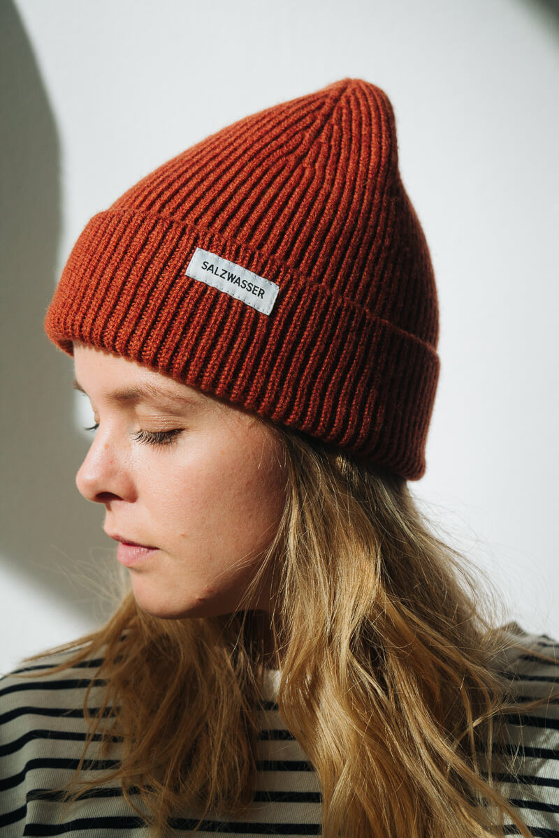 Frau mit roter SALZWASSER Merinowollmütze GOTS-zertifiziert