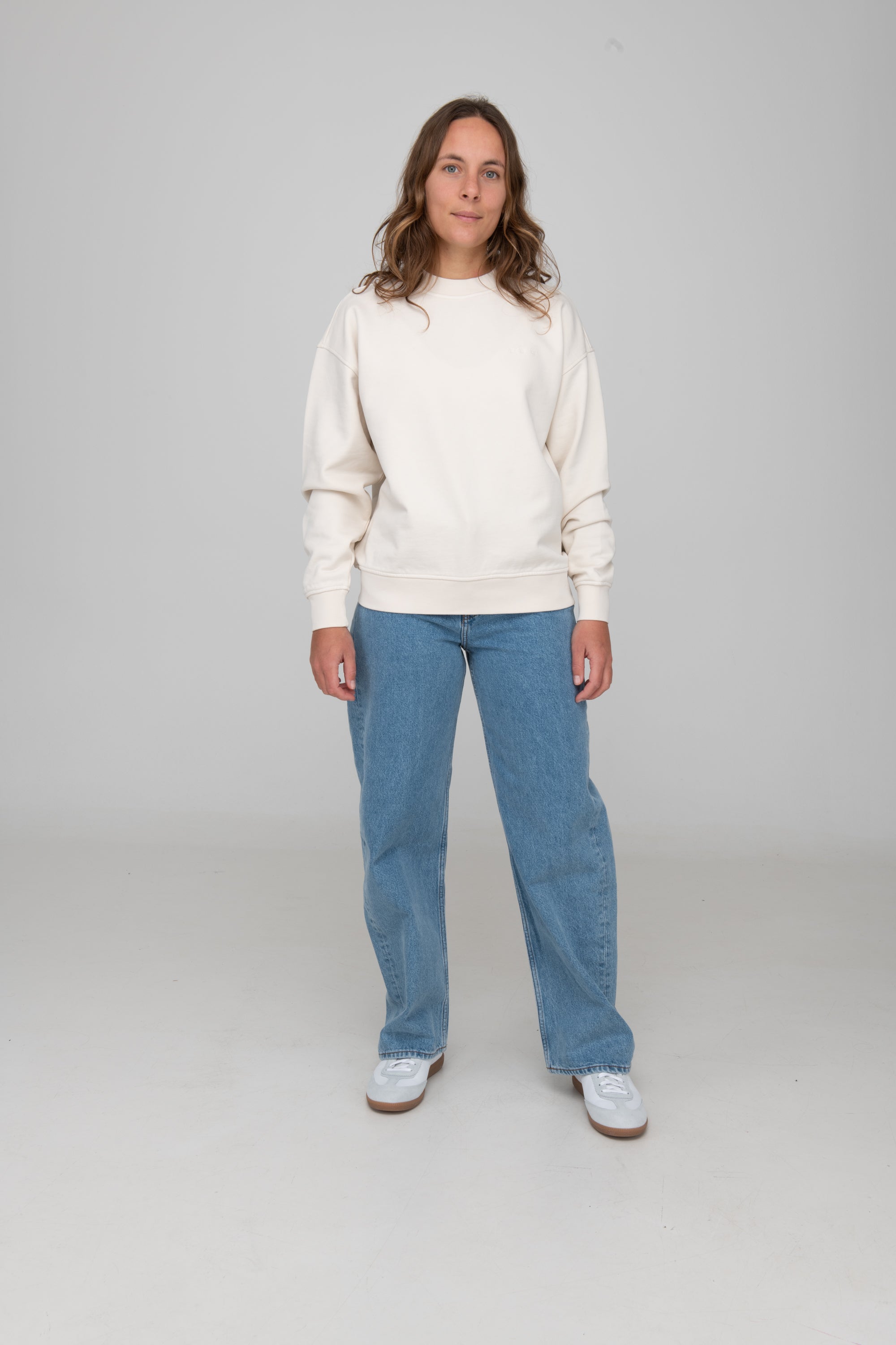 Frau trägt GOTS-zertifiziertes Off-White-farbiger Sweater von SALZWASSER